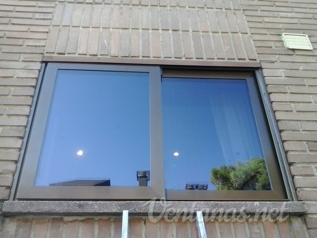 Doble ventana en aluminio perimetral, en color anodizado bronce